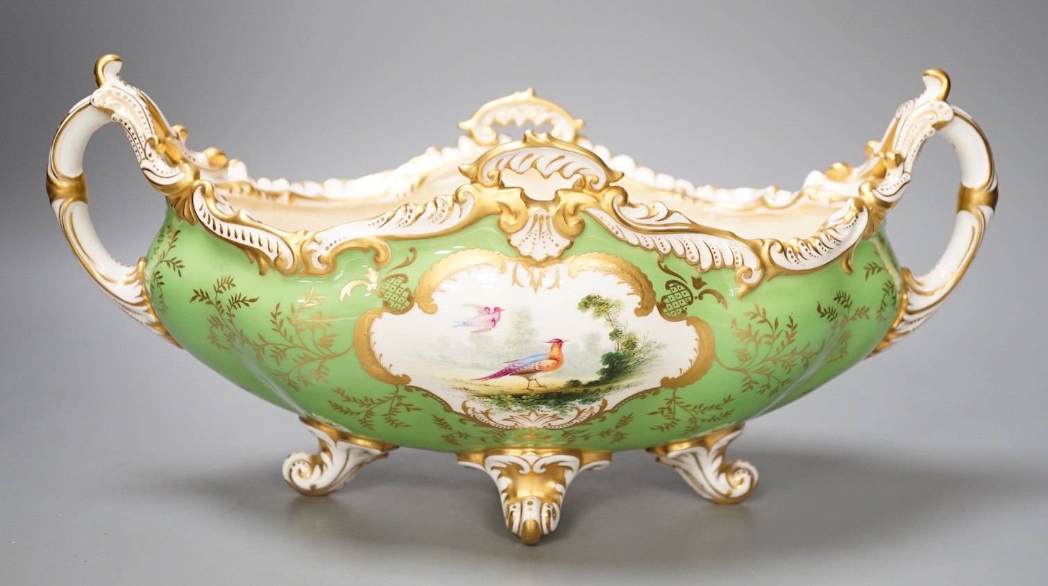 A Coalport twin handled boat shaped vase painted with a bird in panel on a lime green ground, c. 1900, 33cm